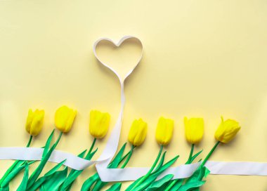 Güneşli sarı çiçek aranjmanı. Sarı kağıtta kalpleri olan sarı, taze laleler. Sevgililer Günü için tebrik kartı, Anneler Günü ya da diğer tatiller için. Seçici odaklanma. Düz yatıyordu. Boşluğu kopyala.