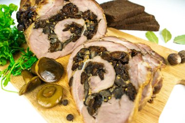 Baharat, defne yaprakları, roka ve beyaz arka planda dilimlenmiş ekmek dilimleriyle süslenmiş kesilmiş kuru erik ve mantarlı fırında köfte..