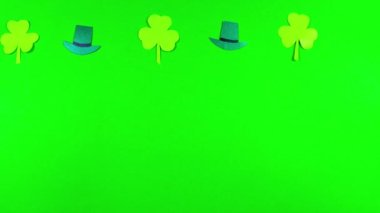 Yeşil arka planda 4k Shamrock yaprakları ve leprikonlar. 17 Mart 'ta kutlanan Aziz Patrick Günü için tebrik kartı. İrlanda kültürel bayramı. Hareket animasyonunu durdur. Boşluğu kopyala.