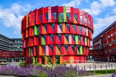 Göteborg, İsveç - 30 Haziran 2019: Kuggen Binası Chalmers Teknoloji Üniversitesi 'ne ev sahipliği yapan vites biçimli bir binadır. Binanın altı farklı tonu kırmızı ve bir yeşil..