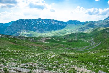 Kuzey Karadağ 'ın pitoresk yüksek dağlık turistik yolunun geçtiği Durmitor Milli Parkı' nın zirveleri. UNESCO Dünya Mirası sitesi. Güzel yaz bulutlu manzarası.