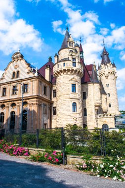 Moszna 'daki saray. Opole Voyvoda 'da tarihi bir konut. Yukarı Silezya, Polonya. Mavi bulutlu gökyüzüne karşı kalenin güzel manzarası. Turist ve Tarihsel Cazibe.