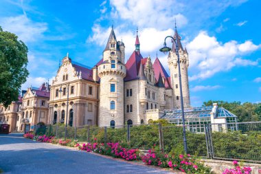 Moszna 'daki saray. Opole Voyvoda 'da tarihi bir konut. Yukarı Silezya, Polonya. Mavi bulutlu gökyüzüne karşı kalenin güzel manzarası. Turist ve Tarihsel Cazibe.