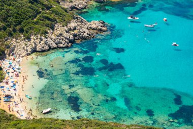 Porto Timoni 'nin hava manzarası, Korfu' nun ya da Kerkyra adasının ana ilgi alanlarından biri. Çam ağaçlarıyla kaplı tepelerin arasında turkuaz plajlı körfezler turistleri çekiyor. Güzel yaz manzarası. Yunanistan.