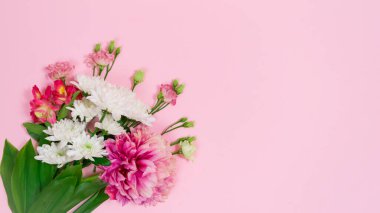 Pembe arka planda bir buket doğal beyaz, pembe ve kırmızı çiçek görünür. Doğum günü kartı, anneler günü, kadınlar günü ya da başka bir gün için tebrik kartı. Uzayı kopyala Düz Yat.