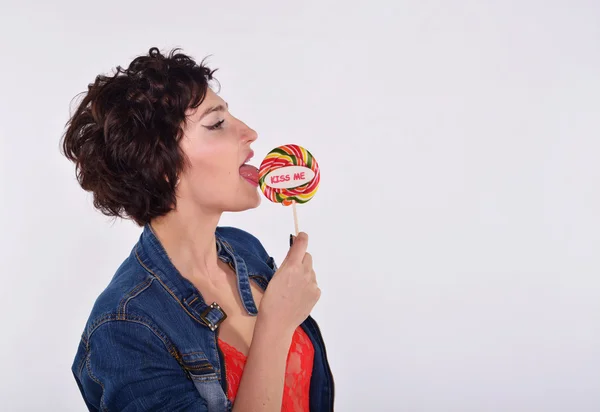 Girl in denim jacket with a round lollipop on a stick — Stock Photo, Image