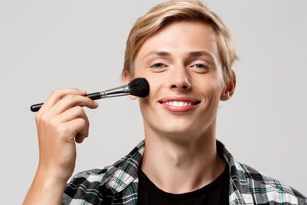 blond man with make-up brush
