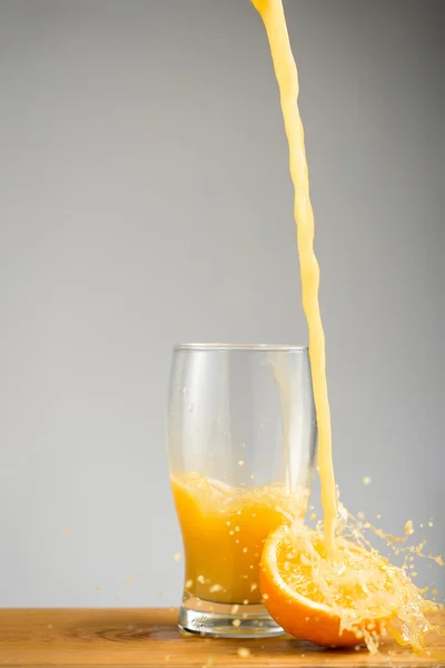 Pouring orange juice into glass.