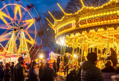 Worcestershire, İngiltere-29 Kasım 2024: Kamu görevlileri Noel şenliği Viktorya Dönemi Fayre 'sinde atlıkarınca atları ve büyük tekerleklerle aydınlık lunapark gezilerinin keyfini çıkarıyorlar..