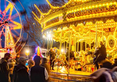 Worcestershire, İngiltere-29 Kasım 2024: Kamu görevlileri Noel şenliği Viktorya Dönemi Fayre 'sinde atlıkarınca atları ve büyük tekerleklerle aydınlık lunapark gezilerinin keyfini çıkarıyorlar..