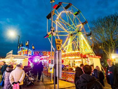 Worcestershire, İngiltere-29 Kasım 2024: Kamu görevlileri Noel şenliği Viktorya Dönemi Fayre 'sinde atlıkarınca atları ve büyük tekerleklerle aydınlık lunapark gezilerinin keyfini çıkarıyorlar..