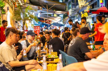 Hanoi, Vietnam-Haziran 06: Gece hayatının keyfini çıkarırken, çoğunluğu gençlerden oluşan kalabalık hafta sonu boyunca şehir merkezinin bu hareketli ve yoğun bölgesinde eğlence, yemek ve bira için toplanıyor..