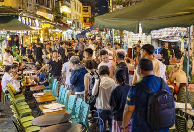 Hanoi, Vietnam-Haziran 06: Gece hayatının keyfini çıkarırken, çoğunluğu gençlerden oluşan kalabalık hafta sonu boyunca şehir merkezinin bu hareketli ve yoğun bölgesinde eğlence, yemek ve bira için toplanıyor..
