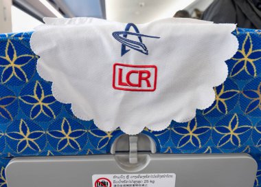 Laos-11 Ocak 2026: Beyaz kumaş koltuk örtüleri, LCR şirket logosuyla, Çin yapımı Boten-Vientiane demiryolu hattında, ikinci sınıf bir vagonun iç koltuğunu süslüyor..