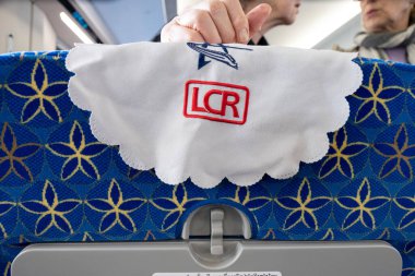 Laos-11 Ocak 2026: Beyaz kumaştan koltuk başlığı örtüleri, LCR şirketinin logosu, Çinlilerin yaptığı Boten-Vientiane demiryolu hattında ikinci sınıf bir vagonun iç koltuğunu süslüyor..