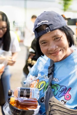 Bangkok-26 Nisan 2025: Günbatımında, AAS Metro Bangkok motorcular bölümü üyeleri yoksullara ihtiyaç duyulan gıdaları dağıtmaya geliyor..