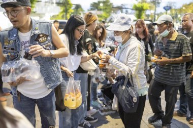 Bangkok-26 Nisan 2025: Günbatımında, AAS Metro Bangkok motorcular bölümü üyeleri yoksullara ihtiyaç duyulan gıdaları dağıtmaya geliyor..