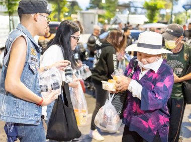 Bangkok-26 Nisan 2025: Günbatımında, AAS Metro Bangkok motorcular bölümü üyeleri yoksullara ihtiyaç duyulan gıdaları dağıtmaya geliyor..