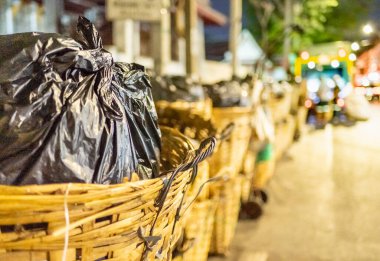 Her akşam çöp, çöp ve çöplerle dolu siyah çöp torbaları belediye çöp arabaları tarafından alınmadan önce sokaklara dökülüyor..