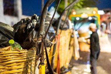 Her akşam çöp, çöp ve çöplerle dolu siyah çöp torbaları belediye çöp arabaları tarafından alınmadan önce sokaklara dökülüyor..