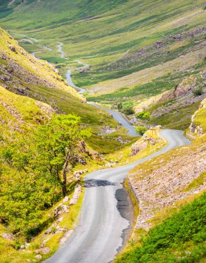 Virajlı yol, B5289, Honister Slate Mine 'dan batıya doğru gidiyor, U manzaralı vadiden geçerek Gatesgarth ve Buttermere Gölü' ne, Ağustos ortalarında..