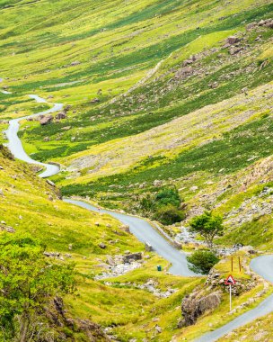 Virajlı yol, B5289, Honister Slate Mine 'dan batıya doğru gidiyor, U manzaralı vadiden geçerek Gatesgarth ve Buttermere Gölü' ne, Ağustos ortalarında..