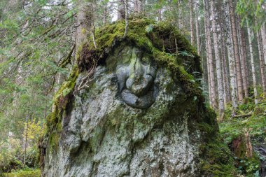 Stone figure beside hiking trail in austria clipart