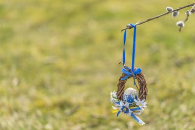 Arka planda yeşil çim ile mavi ve beyaz Paskalya kret