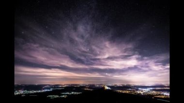 Bisingen Hechingen 'deki Zeller Horn' dan yıldızların ve bulutların gece çekimleri. Almanya 'nın Swabian Alb' inin geniş manzarasında şövalyenin şatosu Burg Hohenzollern 'in manzarası.