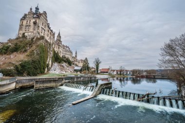 Sigmaringen 'deki Hohenzollern Kalesi' nin ön planda baraj şelalesi ve rezervuarı bulunan fotoğrafı, Almanya