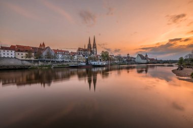 Günbatımında Tuna nehri, katedral ve taş köprü ile Regensburg, Almanya 'da altın saat