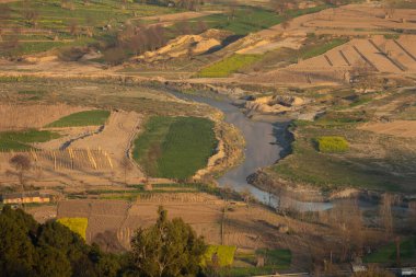 Kırsal alanda nehir ve yeşil tarlaları olan manzaralı tarım arazisi. Balh Vadisi, Himachal Pradesh, Hindistan