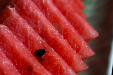 Ferahlatıcı kırmızı karpuz dilimleri, sulu ve tatlı meyveler yaz tatlısı için mükemmel. Bu taze yiyecek sağlıklı beslenme için lezzetli ve iştah açıcı ikram eder.