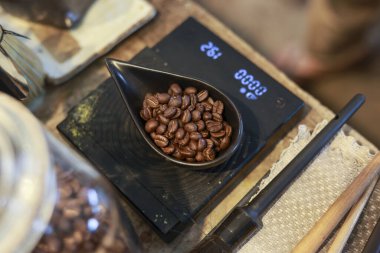 Dijital ölçekte kavrulmuş kahve çekirdeği ağırlığı barista 'nın mükemmel aromatik bardağı hazırlaması için hayati bir adım. kaliteli kahve yapma sanatı ve zanaatı
