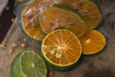 Tahtanın üzerinde yeşil kabuklu taze dilimlenmiş portakalın yakın görüntüsü. İştah açıcı narenciye meyvesi doğal görünüyor ve yemeye ya da sağlıklı meyve suyu yapmaya hazır.