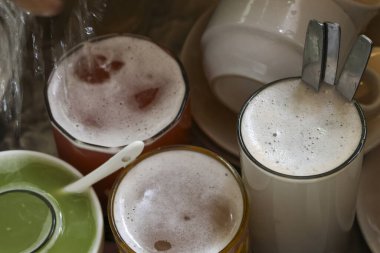 Parti sonrası dağınık, dağınık bulaşık, bardak ve bardak koleksiyonu. Genel bir görüş köpüklü içecekler, yıkanmamış sofra takımı ve lavaboda kaşıklar gösteriyor, kaotik sonuçları yakalıyor.