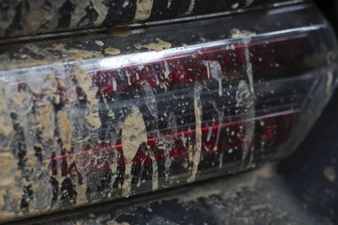 Kirli araba arka lambasının çamurla kaplı olduğu ve engebeli off-road macerasından sonra etrafa saçıldığı detayları kapat. Pislik ve karmaşa güçlü ve heyecan verici bir yolculuk olduğunu gösteriyor.