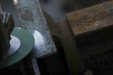 İşyerindeki zanaatkârın, bir endüstriyel atölyedeki taş işleme işi için elmas kesicisiyle öğütme makinesi kullanması. Mermer detaylarına odaklan