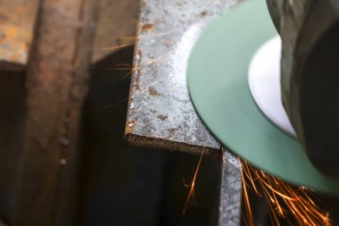 Açı öğütücüyle metal öğütücüye yaklaşıp parlak kıvılcımlar oluşturun. Çelik kesme ve şekillendirme atölyesinde endüstriyel üretim süreci