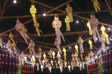 Geleneksel Tayland festivalinde gece kutlaması için kağıt fener süslemesi asıyorum. Ruhani ışık ve canlı kültür tatil için güzel, şenlikli bir ortam yaratır.