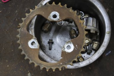 Paslı metal motorsiklet ve diğer parçalar atölyede onarılmayı bekliyor. Çimento ve bakım işlerinin detaylarını gösteren endüstriyel görünümü kapat