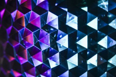 Canlı mor ve mavi üçgenlerin geometrik desenleri ile soyut arkaplanı büyülüyor. Bu fütüristik tasarımın karanlık yansıtıcı yüzey üzerinde soğuk neon ışığı etkisi vardır.