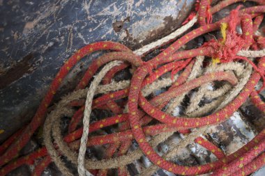 Kirli yüzeyde eski bir kırmızı halatı, karmakarışık bir karmaşanın içinde kapat. Bu soyut, yıpranmış doku karmaşa hissi ile detaylı bir arkaplan sağlar