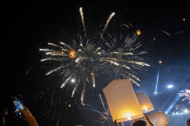İnsanların güzel havai fişek gösterilerini izlediği gece festivalinde neşeli bir kutlama. Parlayan gökyüzü feneri karanlık gökyüzüne doğru süzülür, muhteşem ışık gösterisi