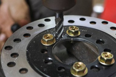 Matkap ucu mekanik metal fren diskine odaklanmış. Atölyenin bir parçasını titizlikle kişiselleştirmek, talaş yaratmak. Tamir ve bakım için endüstriyel üretim süreci