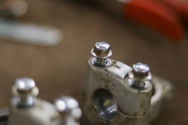 Metal cıvataya odaklanmış ve makine kısmına vidalamış. Bu endüstriyel detay makine atölyesinde montaj sırasında motor tamir ve bakım çalışmalarını gösteriyor