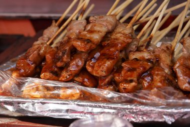 Folyo soslu leziz ızgara domuz şişleri. Asya sokak yemeği barbeküsünü kapatın. Lezzetli yemekler için geleneksel ve iştah açıcı atıştırmalıklar.