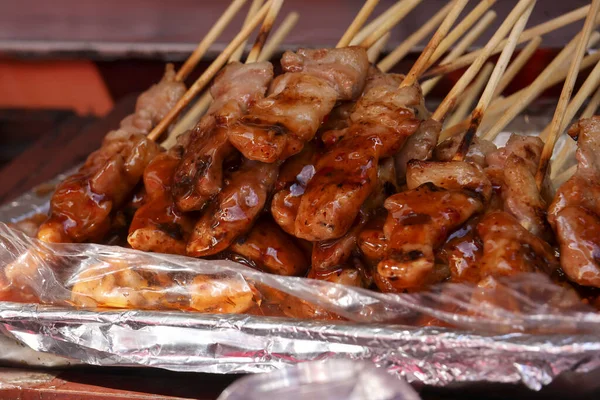 Folyo soslu leziz ızgara domuz şişleri. Asya sokak yemeği barbeküsünü kapatın. Lezzetli yemekler için geleneksel ve iştah açıcı atıştırmalıklar.