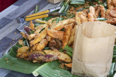 Kızarmış muzlu börek, popüler Malezya sokak yemekleri. Bu geleneksel Asya ziyafetinde yeşil muz yaprağı tatminkar ve otantik mutfak deneyimi sunuluyor.