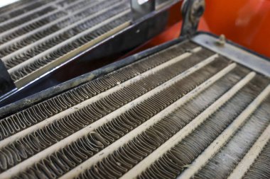 Kirli eski araba radyatörü tamir edilmesi gereken araç soğutma sistemini kapatıyor. Aşırı ısınmadan dolayı tıkanmış ve bükülmüş yüzgeçler için otomotiv bakımı gerekiyor